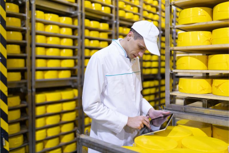 tecnologo tunica blanca cerca estantes quesos produccion productos queso hombre tienda quesos